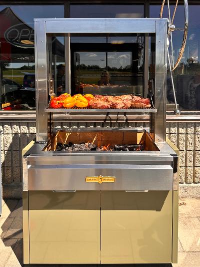 Outdoor live-fire grill cooking meat and vegetables over an open flame